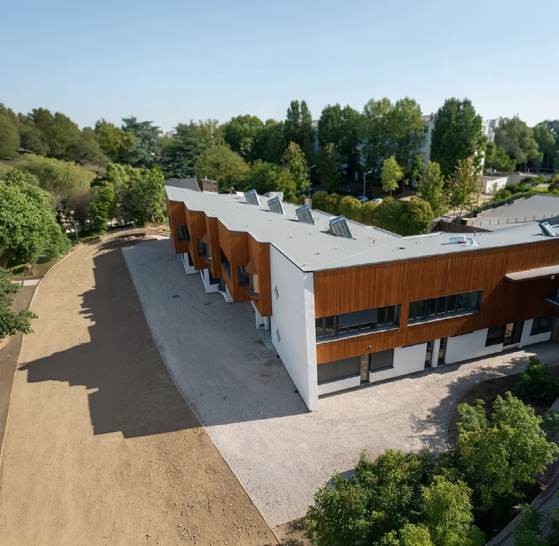 Vue aérienne de l’école élémentaire Antoine de Saint-Exupéry livrée à Trappes avec bardage bois et Cour Oasis